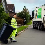 Skraldemand tømmer affaldsbeholder